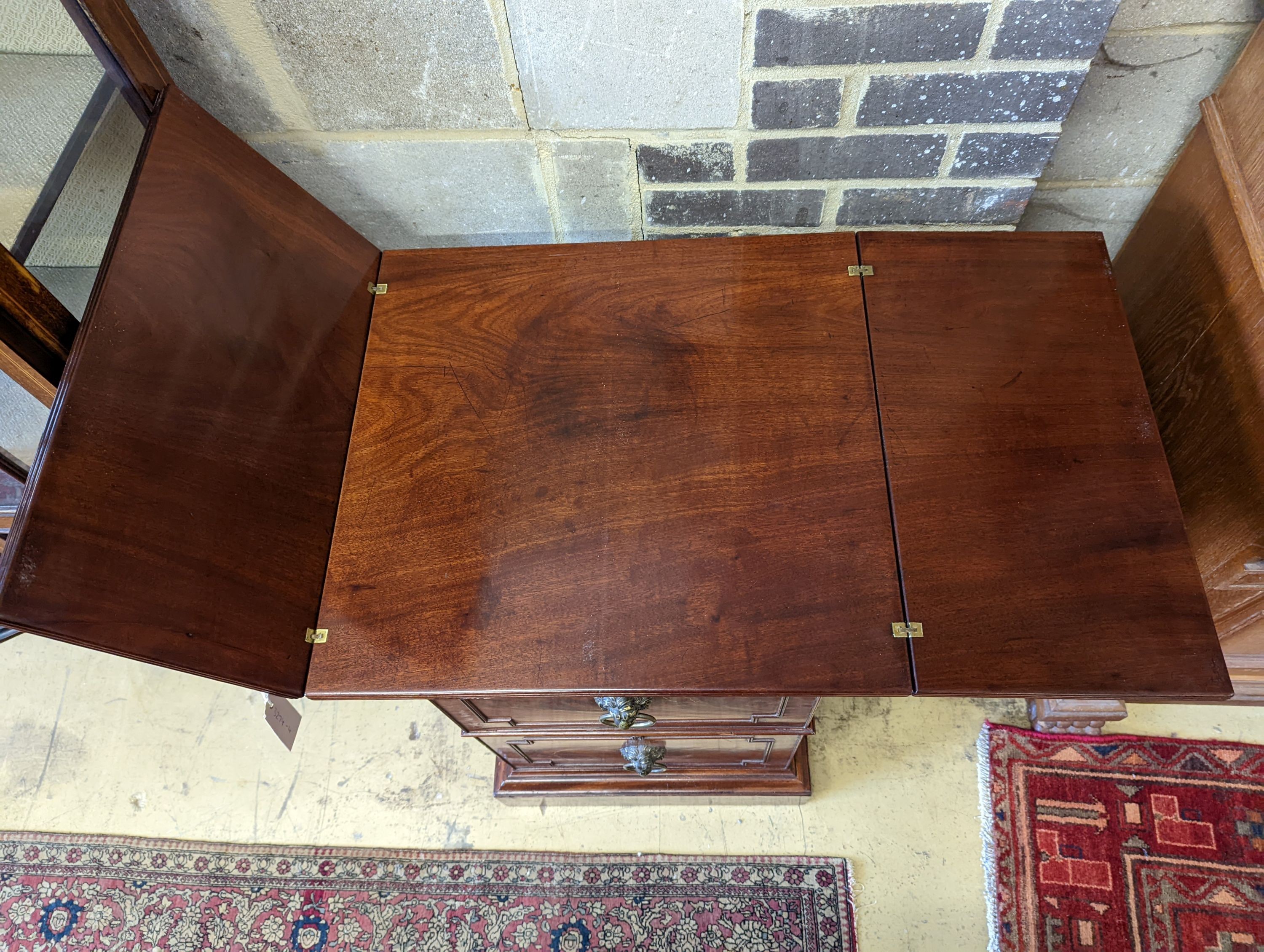 A George III mahogany pedestal designed by C. Wilson, with twin flap top, cellaret drawer now with two decanters and base cupboard, width 53cm, height 87cm